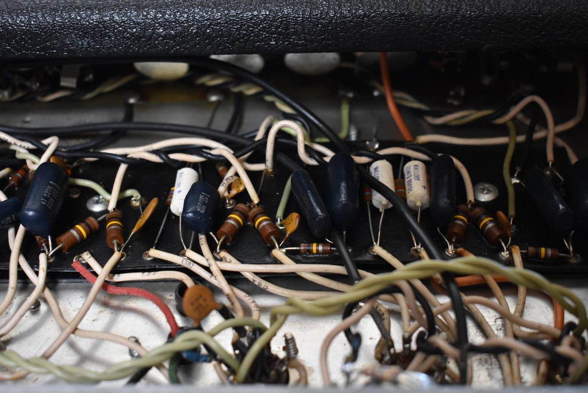 Close-up of the amplifier's internal wiring, showing a dense network of colorful wires, resistors, and capacitors on a dark circuit board.