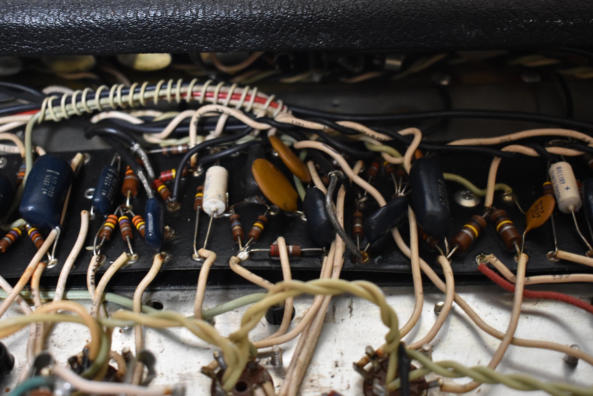 Close-up of the amplifier's internal wiring, showing a dense network of colorful resistors, capacitors, and insulated wires on a black circuit board.