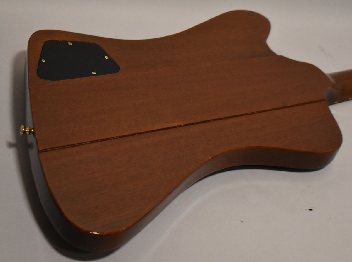 The back of the Firebird's body, showing its natural wood finish, black control cavity cover, and a gold strap button.