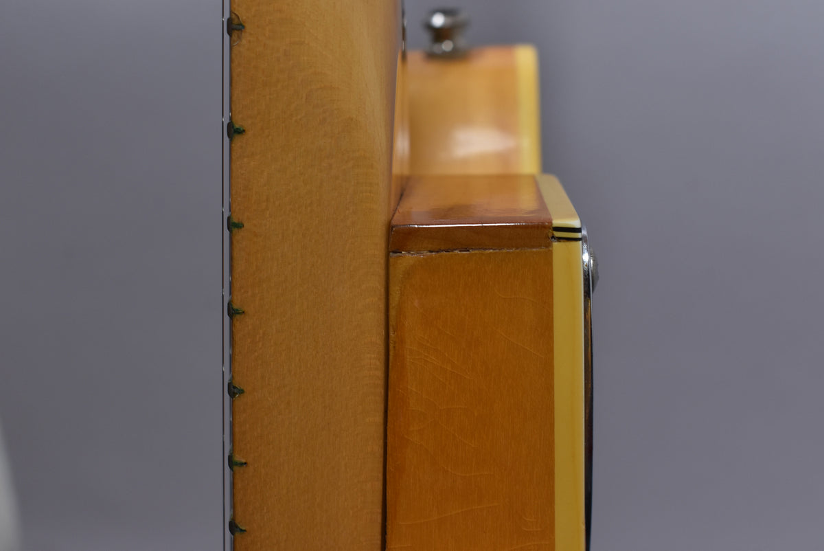 Close-up of the natural flame maple body's side, showing the cream binding, chrome hardware, and some finish wear near the neck joint.