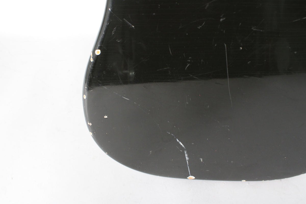 Close-up of the bass's lower body, showing heavy wear, scratches, and paint chips on the black finish, revealing lighter wood underneath.