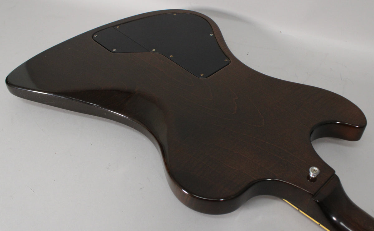 The back of a dark walnut guitar body, angled from the lower bout to the upper horn, shows two black control cavity covers.