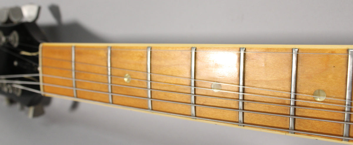 Close-up of the guitar's maple fretboard, showing frets 1-7, with dot inlays and some light wear on the finish.