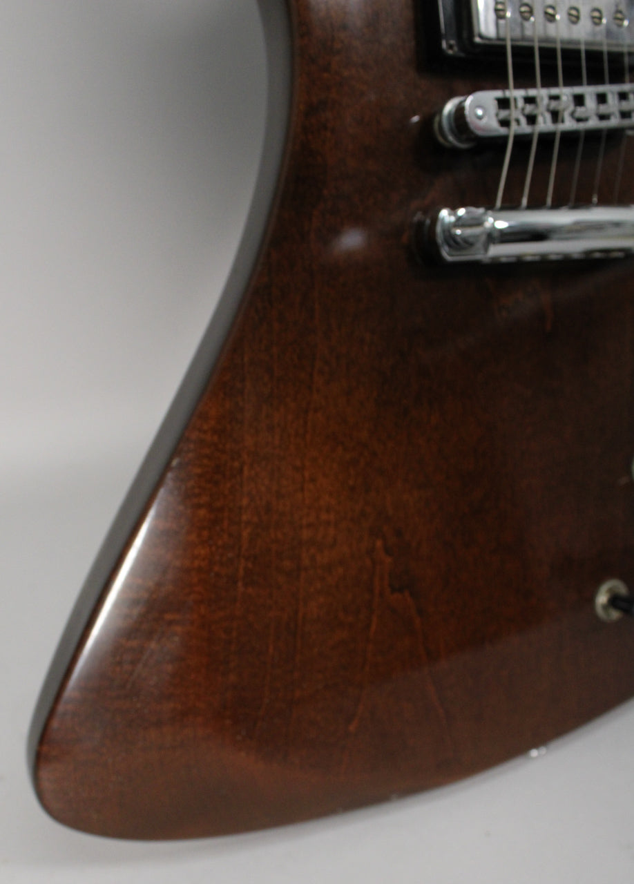 Close-up of the guitar's lower bout, showing the dark walnut finish, chrome bridge, and a few minor surface scratches.