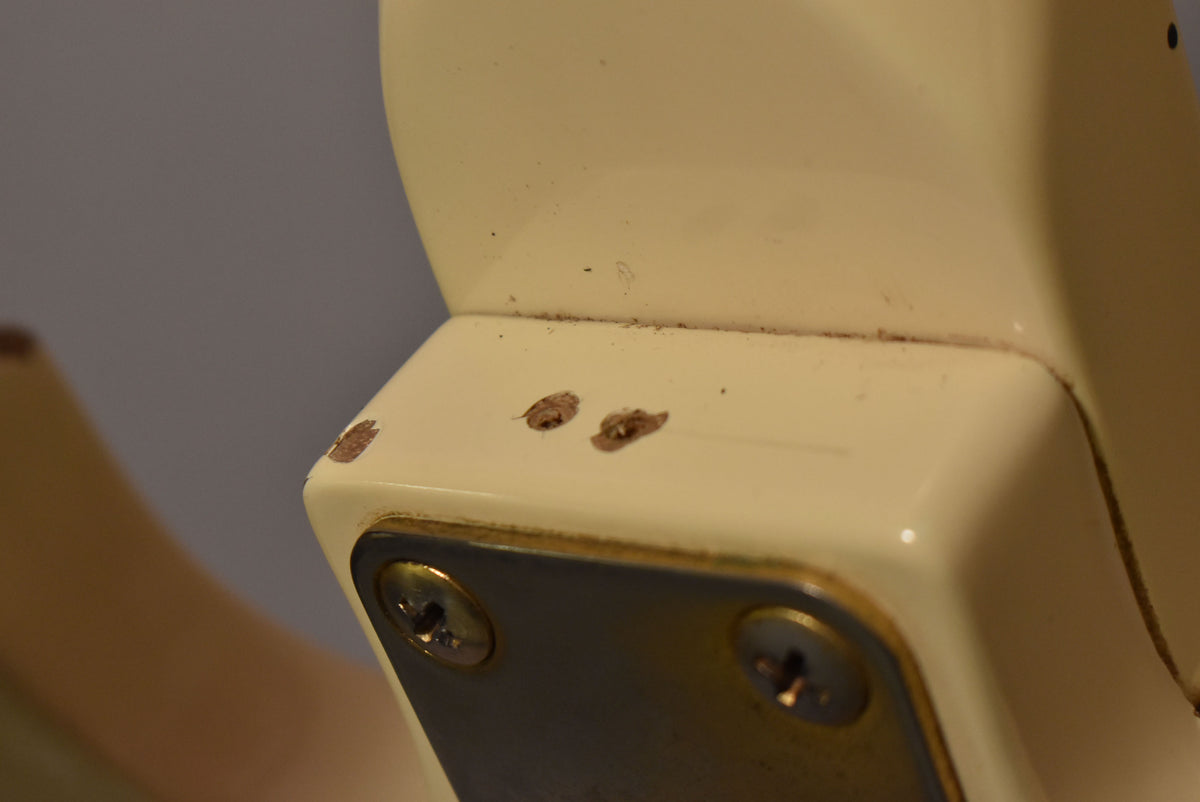 Close-up of the guitar's cream body, showing three large chips in the finish revealing the wood beneath, near a metal neck plate.