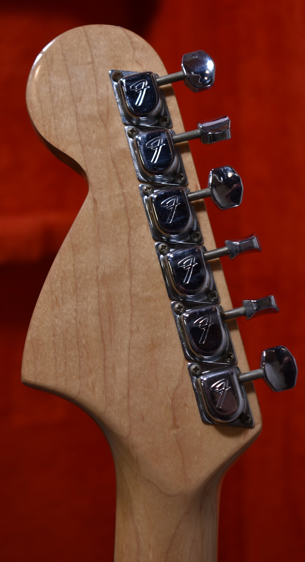 Rear view of the guitar's maple headstock and neck, showing six chrome tuning machines with "F" logos and light wear.