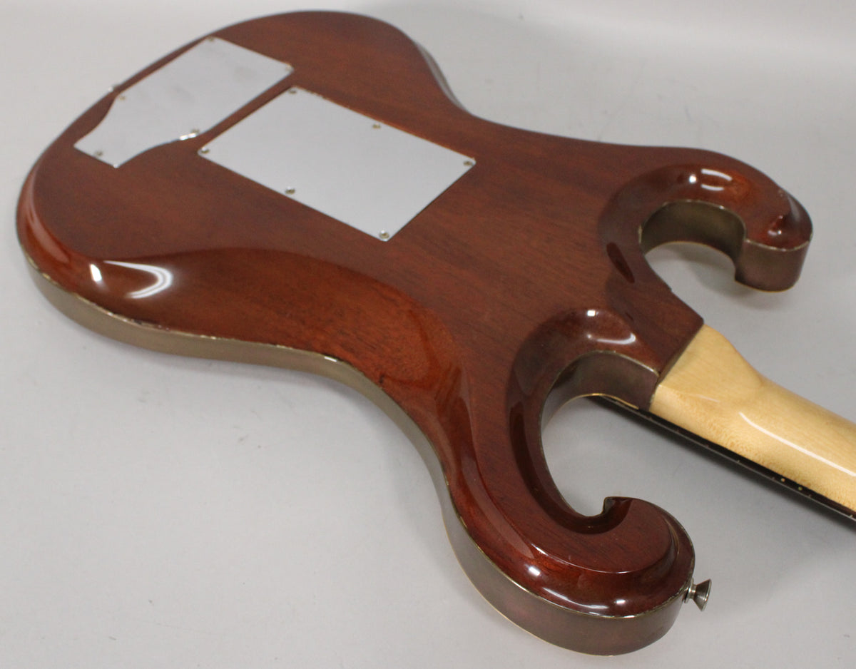 The guitar's dark cherry back shows two white control cavity covers, a light maple neck, and a strap button.