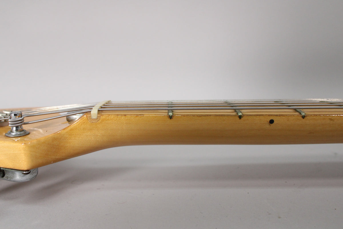 Close-up of the maple neck and fretboard from the nut to the third fret, showing light wear and a black dot inlay.