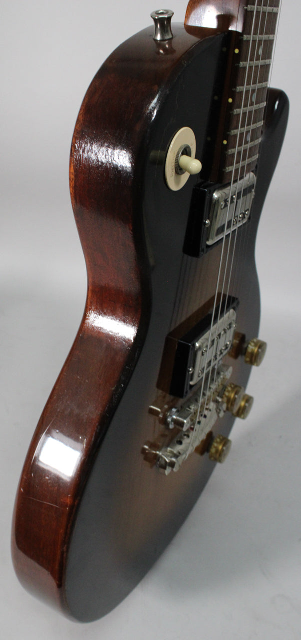 The tobacco sunburst electric guitar is angled right, showing its glossy dark brown body, chrome hardware, and cream switch.