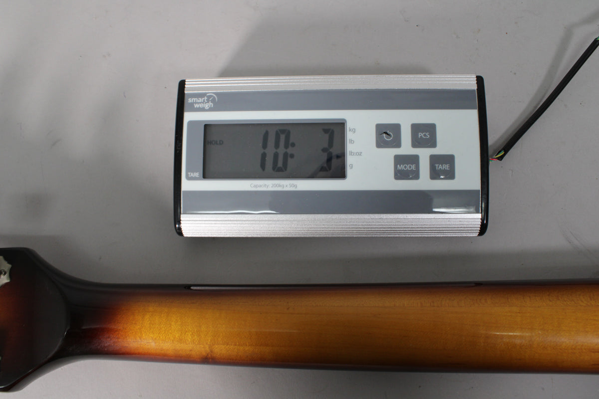 A Smart Weigh scale displays "10.3" lbs, with a tobacco burst guitar neck partially visible below it.