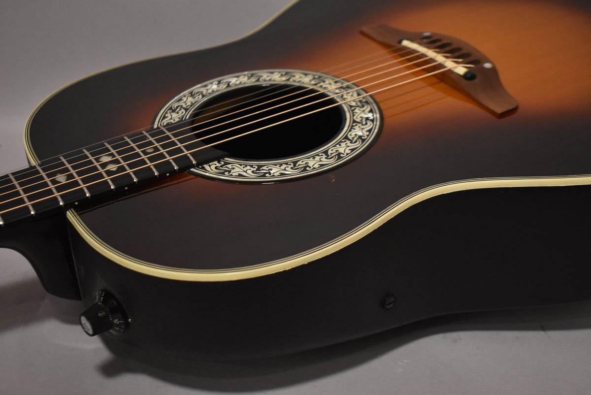 Close-up of the sunburst body, showing the ornate soundhole rosette, bridge, and a volume knob on the lower bout.