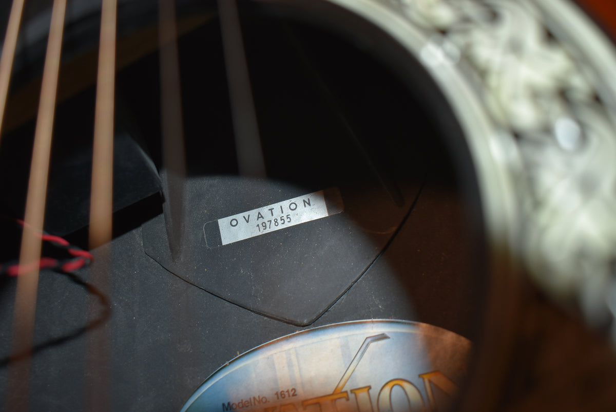 Close-up of the guitar's interior, showing a white label with "OVATION 197855" and a partial round label below.