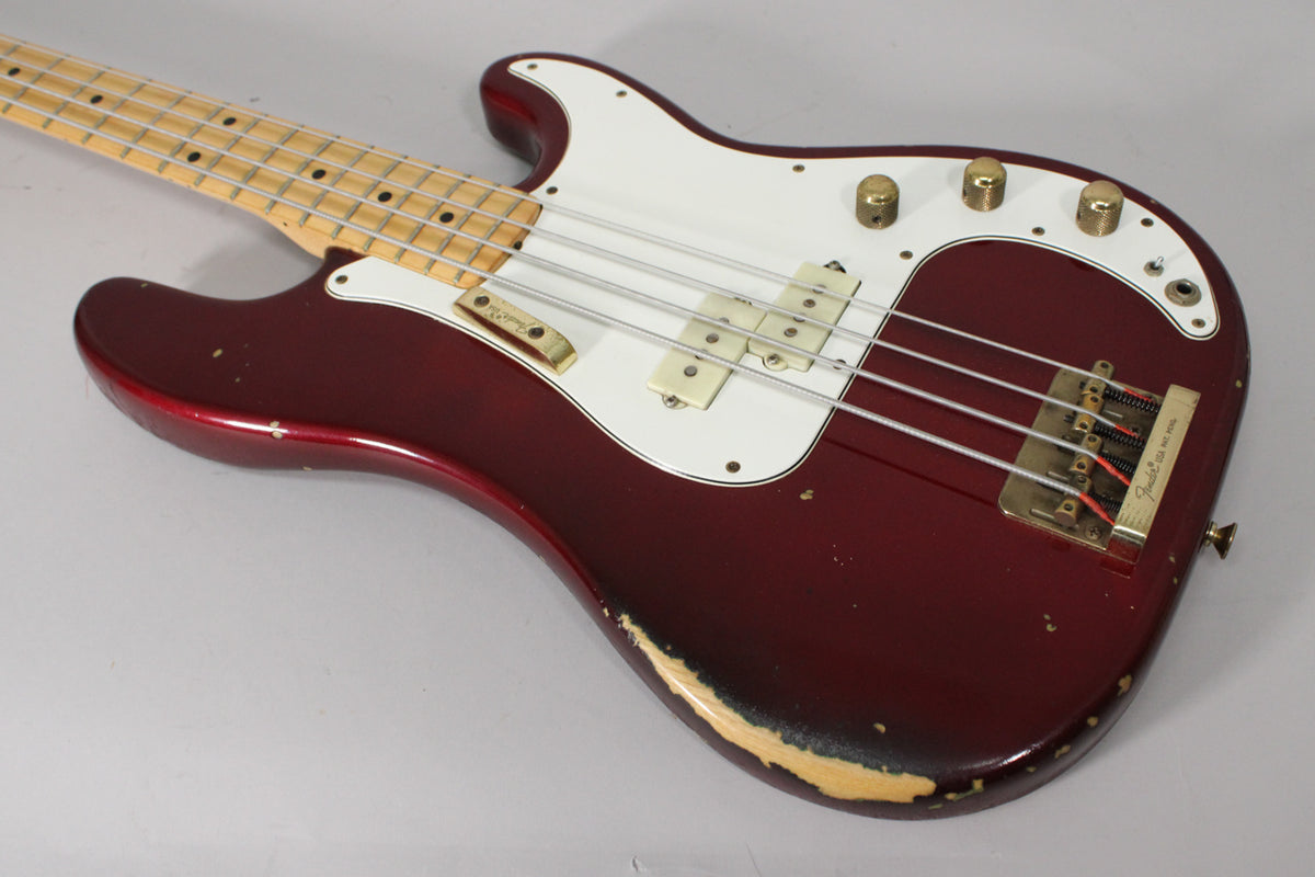 Candy Apple Red bass, angled from the neck to the lower bout, showing heavy wear on the lower edge and gold hardware.