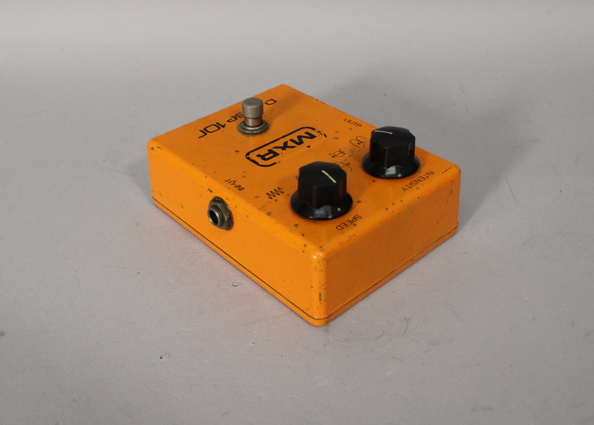 Orange pedal with a silver footswitch, two black control knobs, and visible wear on the edges and top surface.