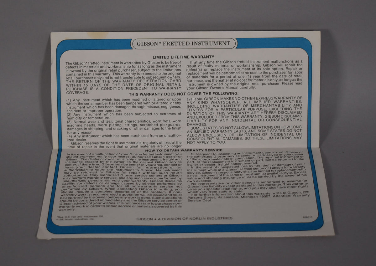 A full, slightly angled view of the white Gibson Fretboard Instrument Limited Lifetime Warranty card with blue border.