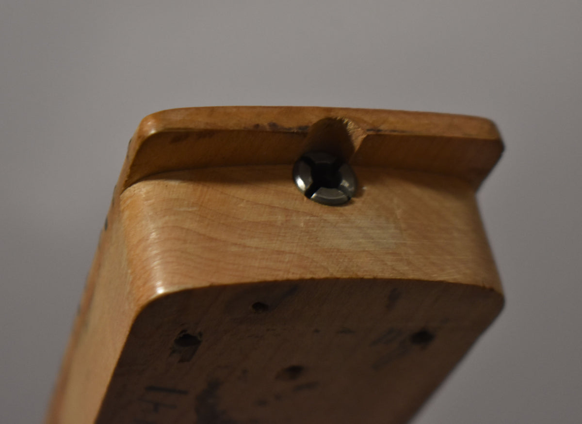 Close-up of the maple neck heel, showing a truss rod adjustment screw and four body mounting holes on the bottom.