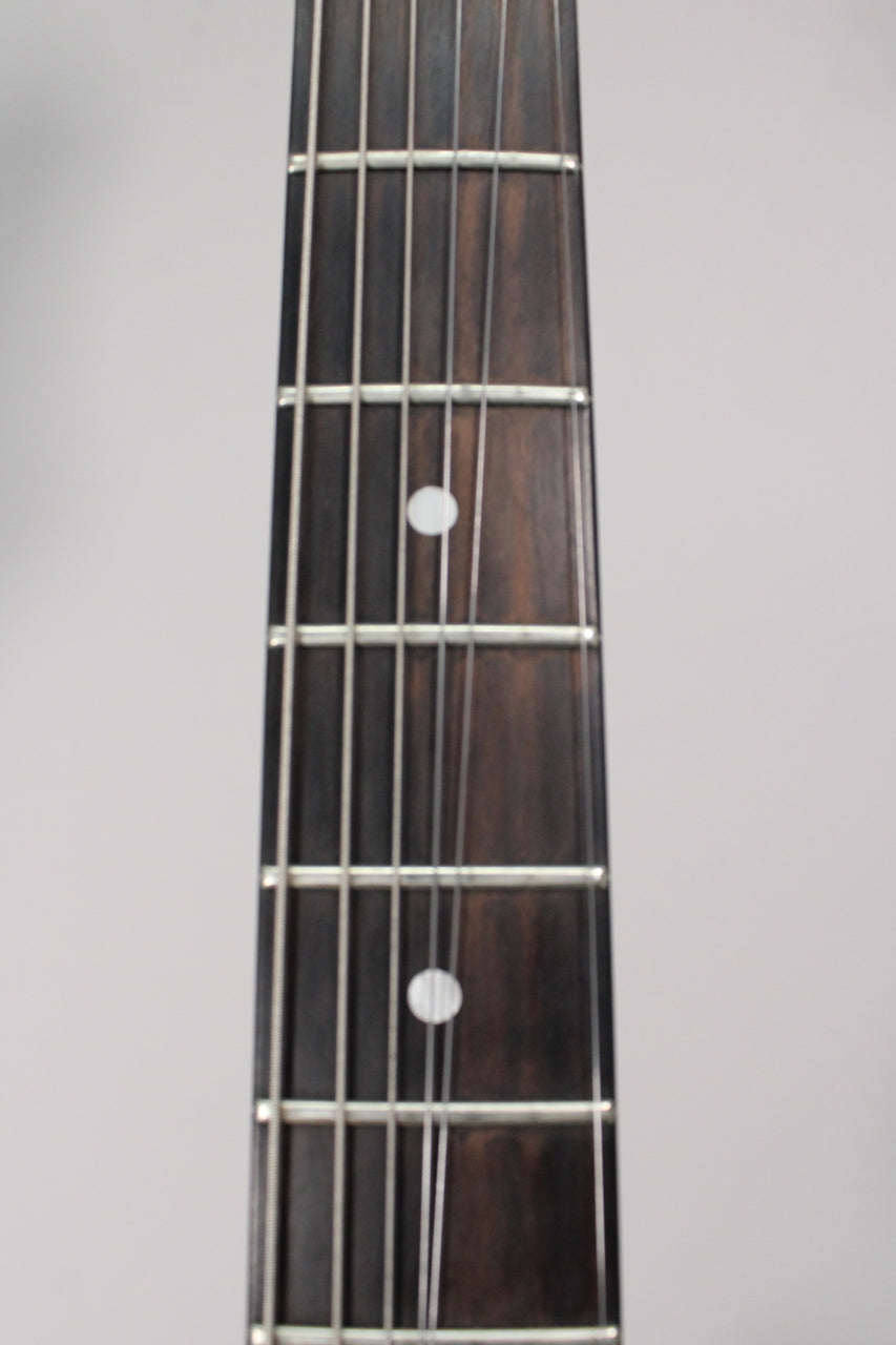 Close-up of the dark rosewood fretboard, showing frets 5 through 9 with white dot inlays on frets 5 and 7, and light string wear.