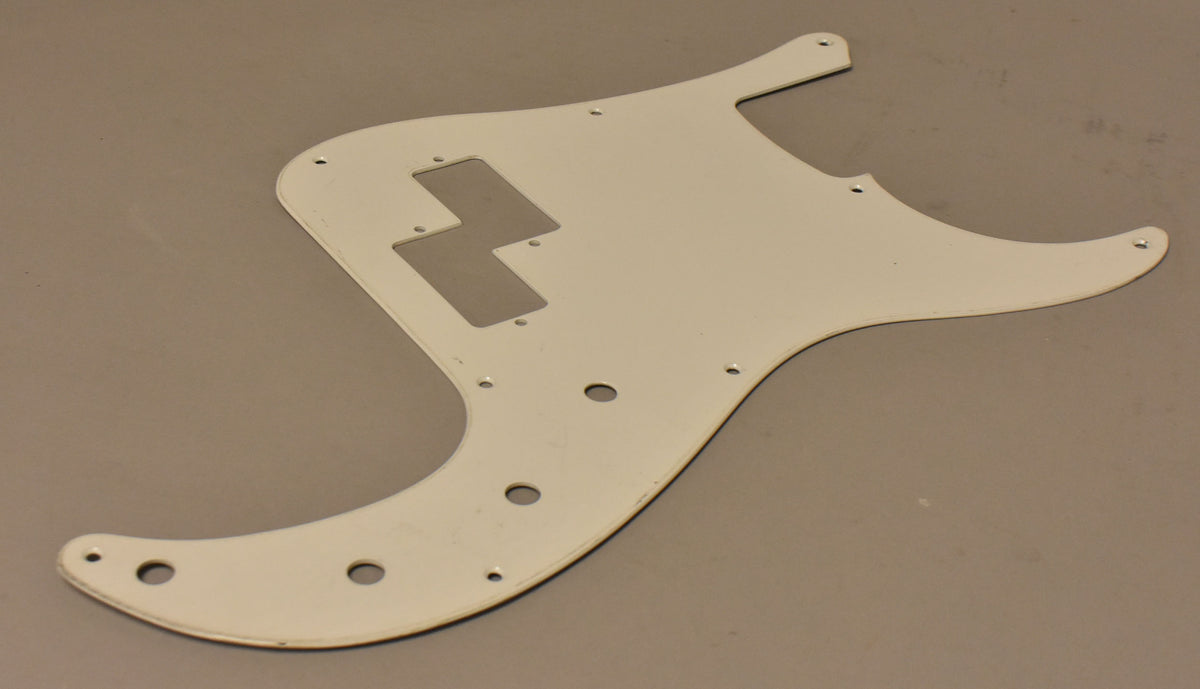 The white aluminum pickguard is shown from above, angled slightly, revealing a few minor scuffs and a slight yellowing.