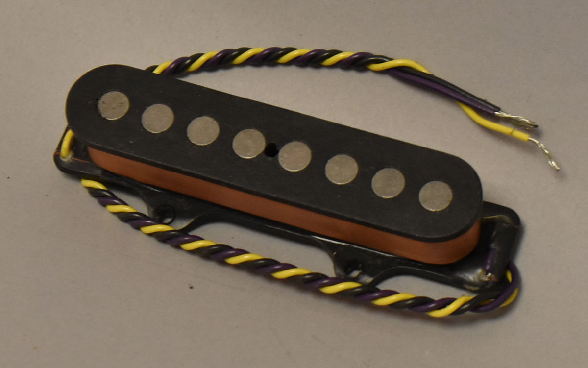 Black pickup with eight silver pole pieces, a brown bobbin, and yellow and purple braided wire with stripped ends.
