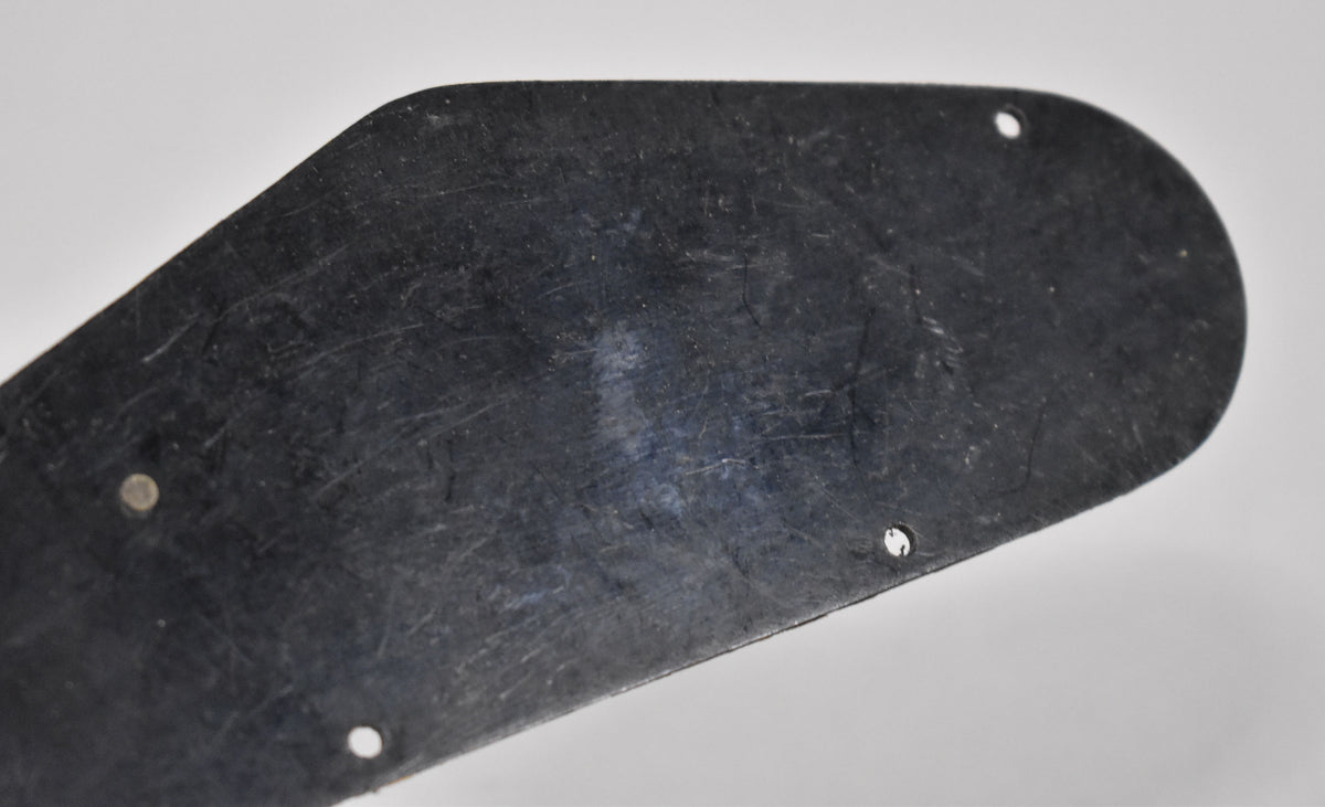 Close-up of the black plastic back plate, showing its textured, matte finish with light surface scratches and three screw holes.