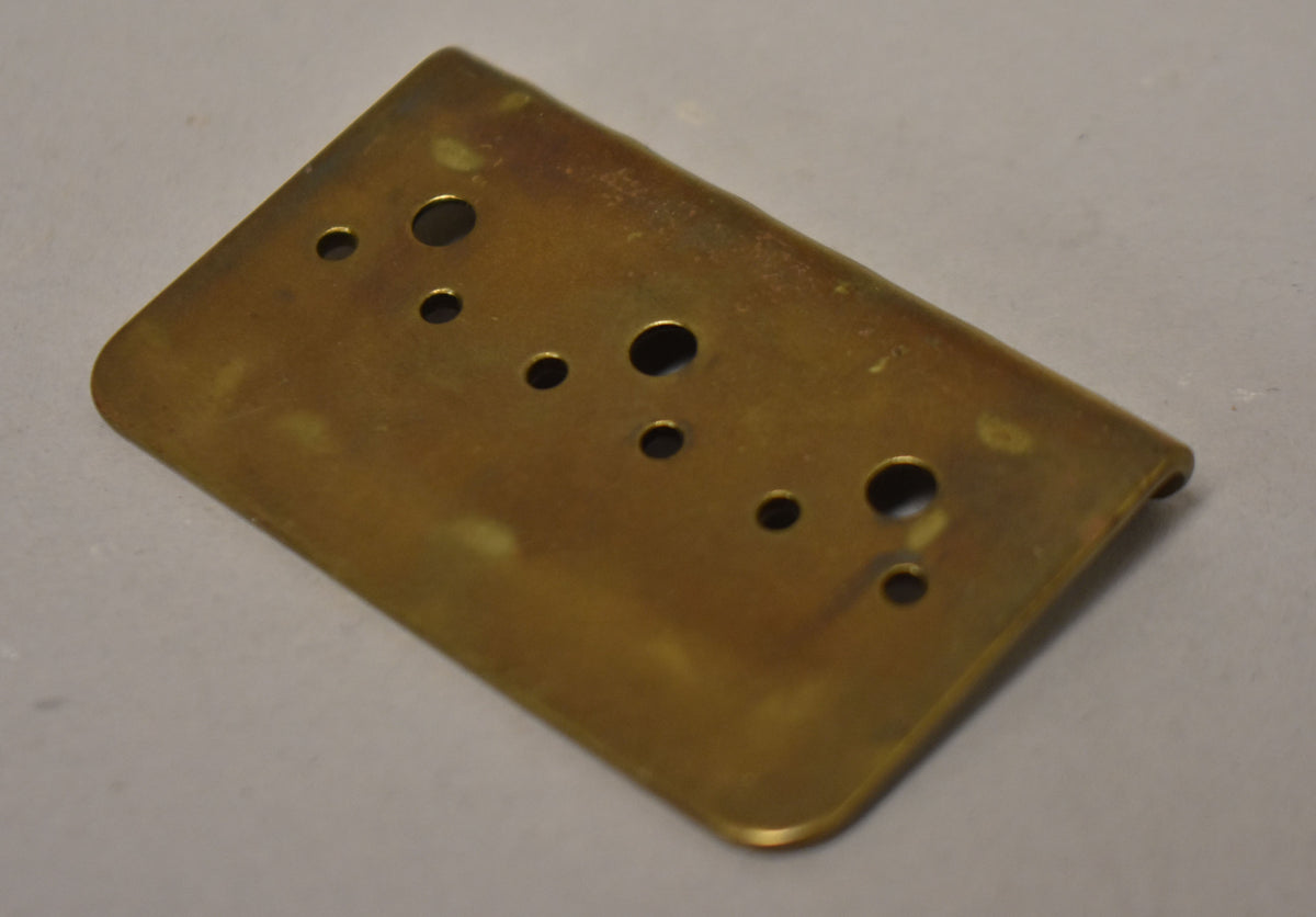 Gold hardtail bridge plate, viewed from above, shows six string-through holes and three mounting holes, with some tarnishing.