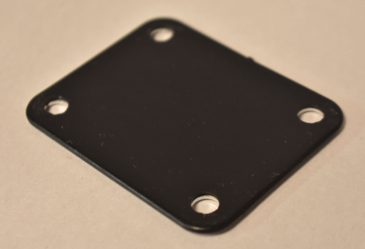 Close-up of a black, rectangular neck plate with rounded corners, showing four screw holes and a few minor surface scuffs.