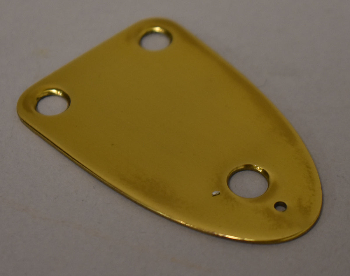 A shiny, golden, teardrop-shaped brass neck plate with three screw holes, two at the top and one at the bottom.