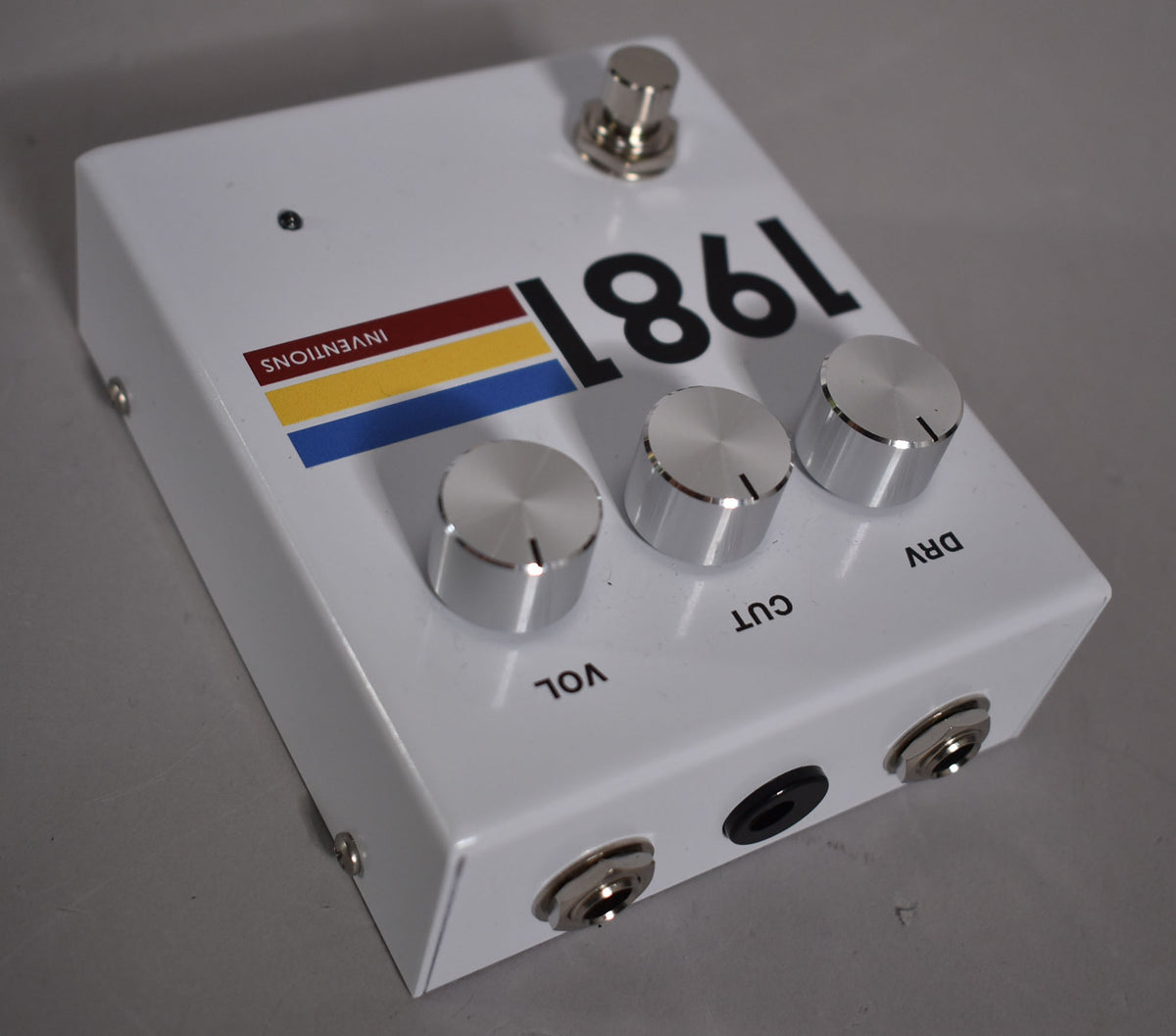 White overdrive pedal, angled view of the top and front, with three silver control knobs and a footswitch.