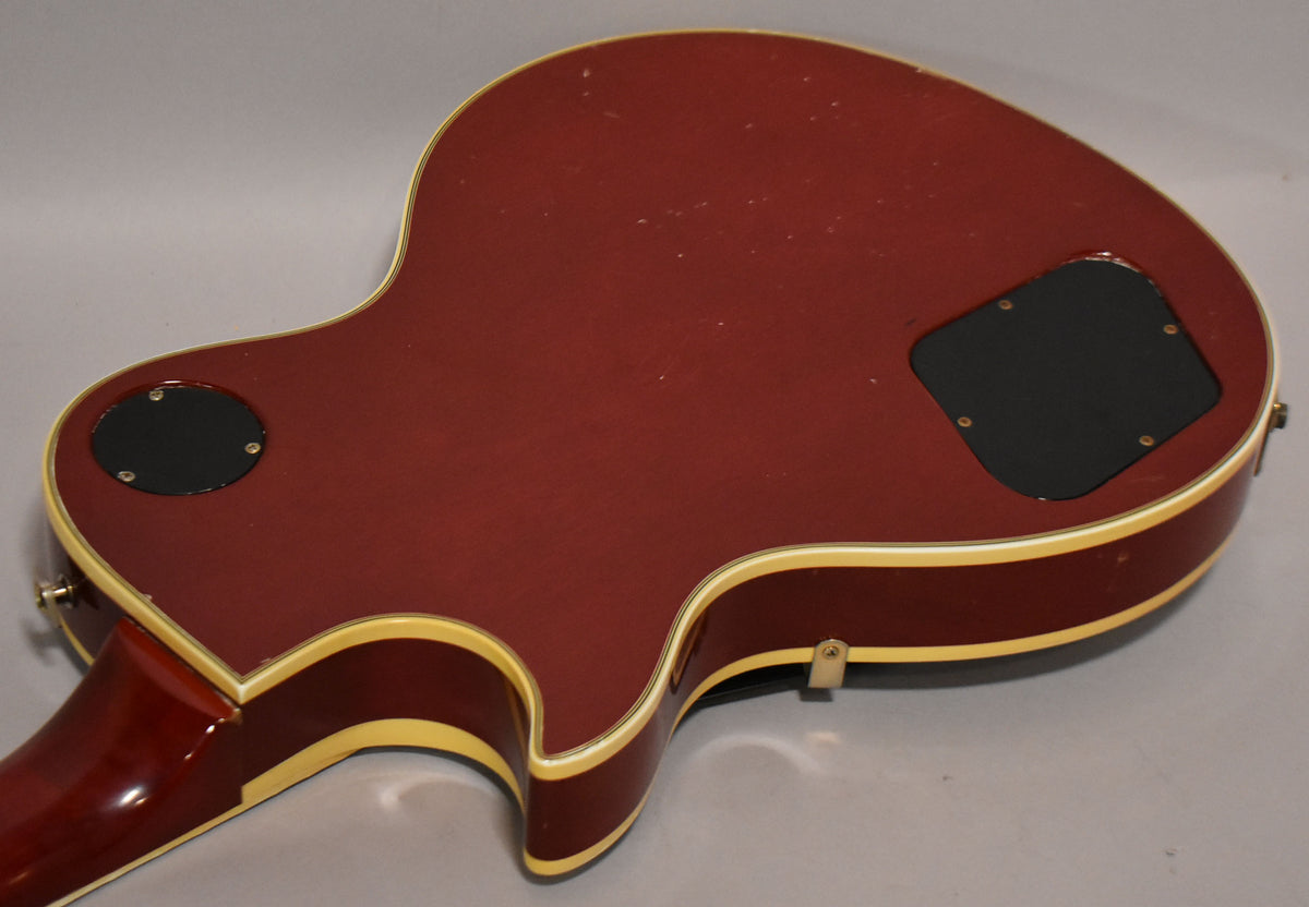 The guitar's cherry sunburst back, with cream binding, shows light surface scratches and two black control cavity covers.