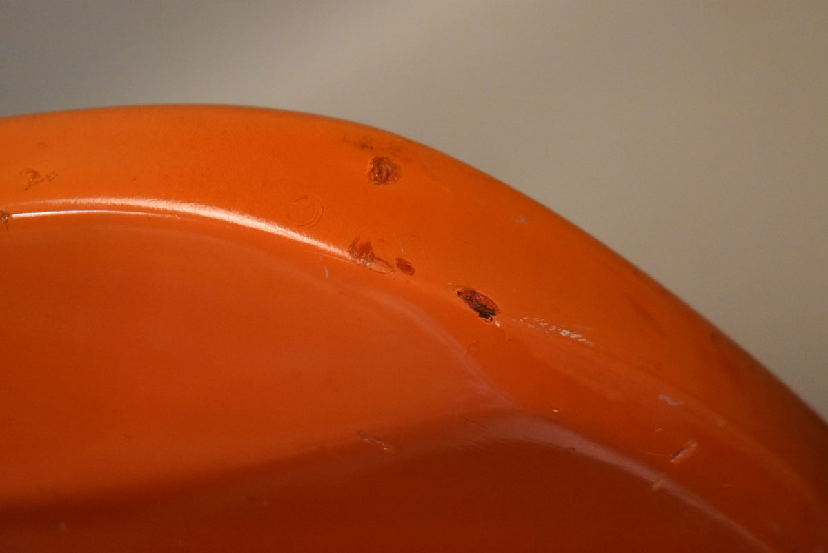 Close-up of the guitar's faded orange body, showing several chips and dings in the finish along a curved edge.