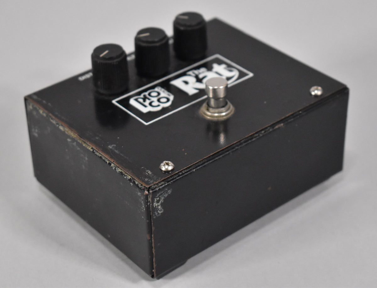 Angled view of the black pedal, showing three black control knobs, a silver footswitch, and significant paint wear on the edges.