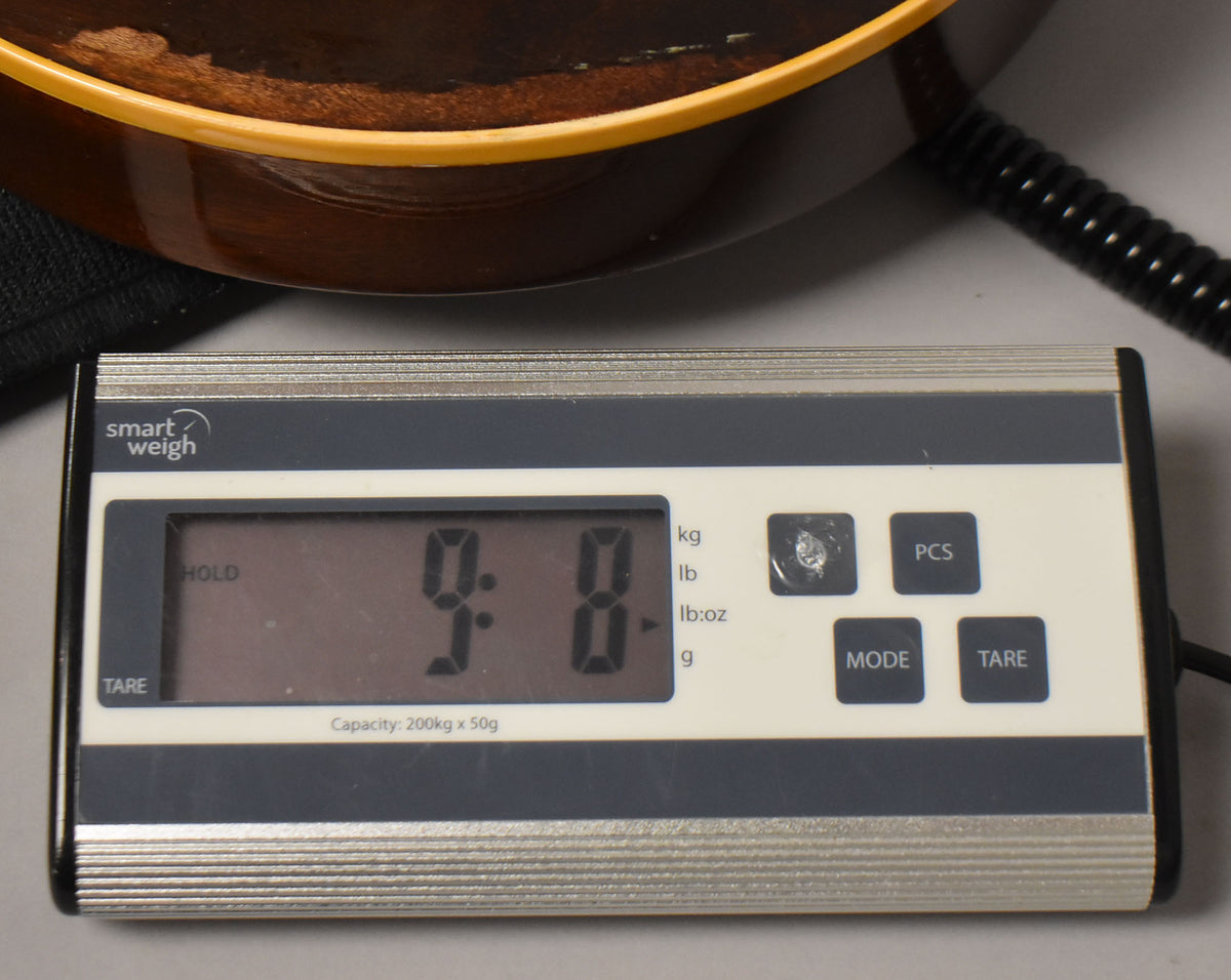 Close-up of the guitar's lower bout on a digital scale, displaying "9.8" lbs, with some finish wear visible on the dark brown body.