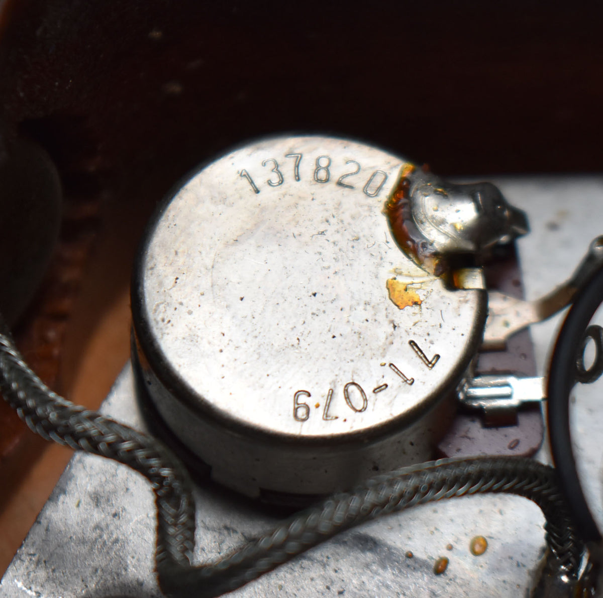 Close-up of a silver potentiometer with "137820" and "670-1L" stamped on it, showing solder joints and braided wire.