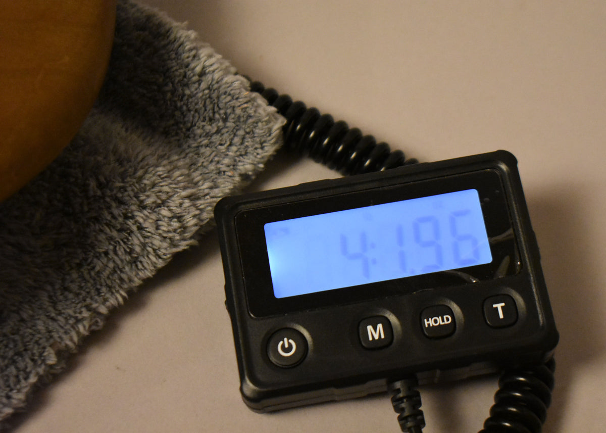 Close-up of a digital scale displaying "4.19.6" in blue, with a fuzzy gray cloth and part of a light brown object visible.