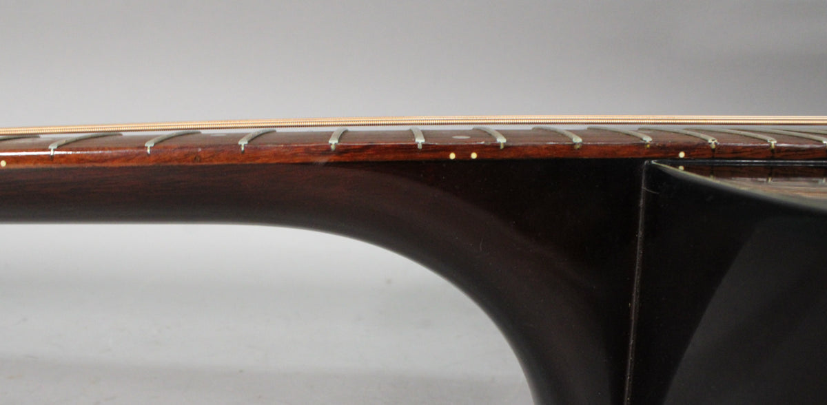 Close-up of the dark brown neck and fretboard, showing light wear on the frets and a few small dings on the side dots.