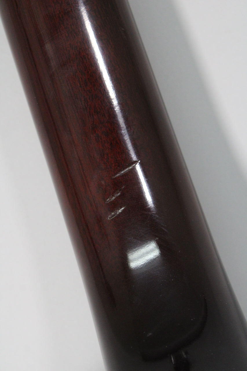 Close-up of the dark reddish-brown neck with a glossy finish, showing three distinct scratches on the upper side.