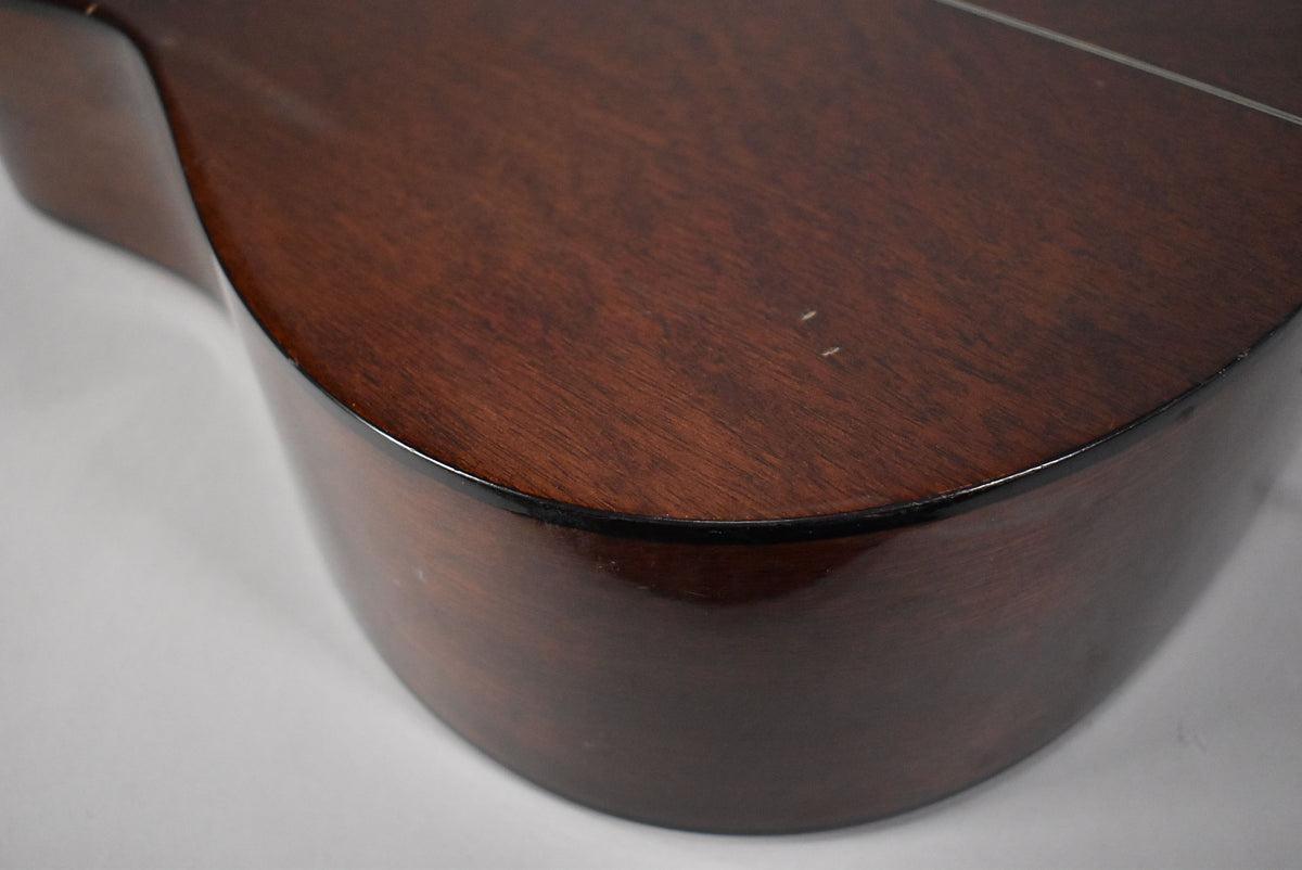 Close-up of the lower bout, showing the dark brown body with a glossy finish and two small white scuffs on the top.