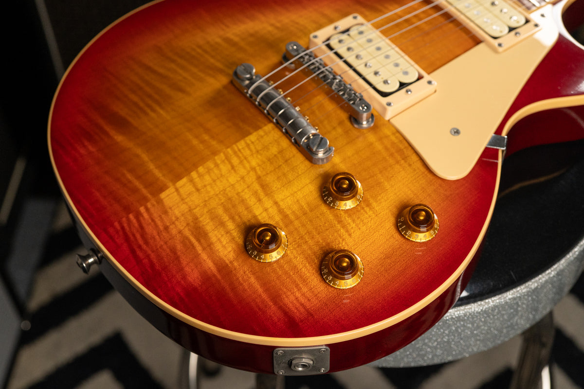 The guitar's cherry sunburst flame top, with four amber speed knobs, two cream humbuckers, and a tune-o-matic bridge.