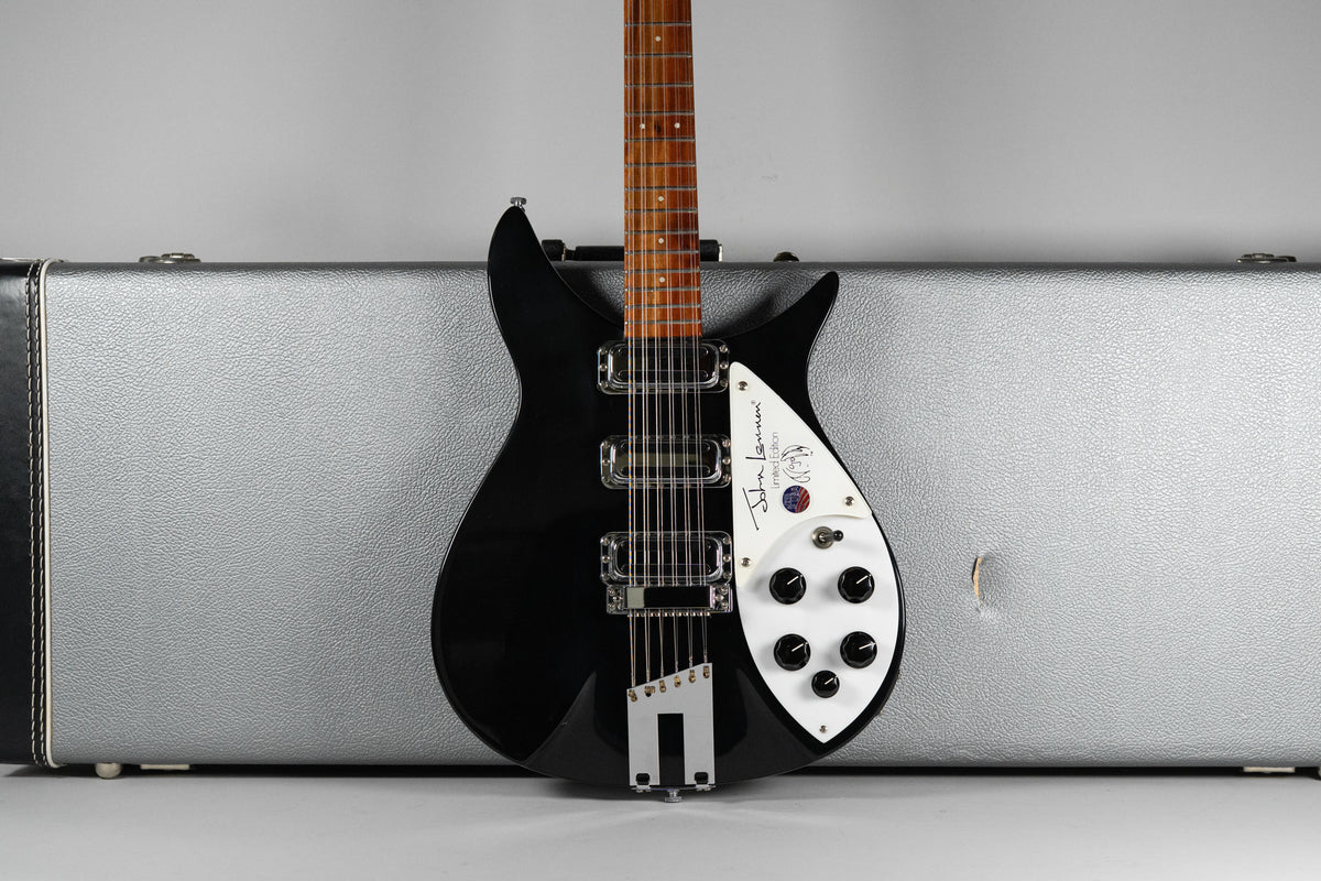 Full-front view of a glossy black 12-string electric guitar with a white pickguard, chrome hardware, and a light brown fretboard.