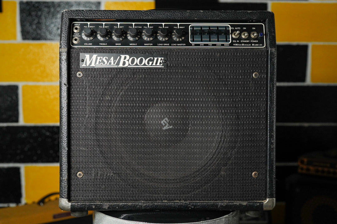 Front view of a black tolex combo amp with a black grille, showing silver corner protectors and some scuffs.