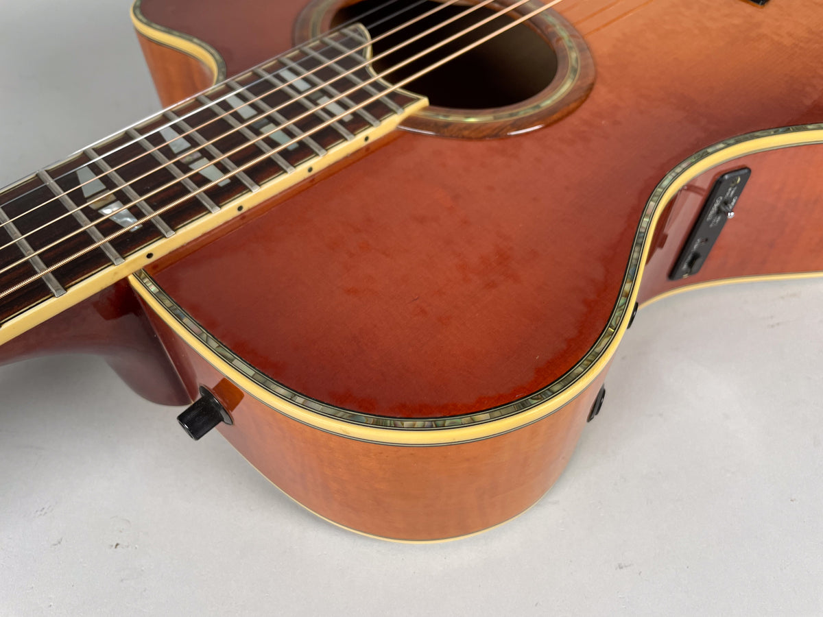 Close-up of the sunburst body and lower fretboard, showing the preamp controls on the upper bout and a black knob on the lower bout.