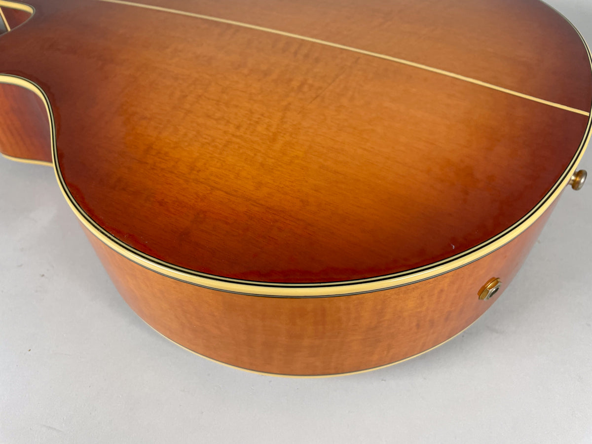 Close-up of the sunburst body, showing the lower bout and side with a visible output jack and a few small dings.