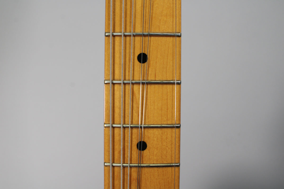 Close-up of a guitar fretboard with six strings, showing frets 5 through 9, with black dot inlays on frets 7 and 9.