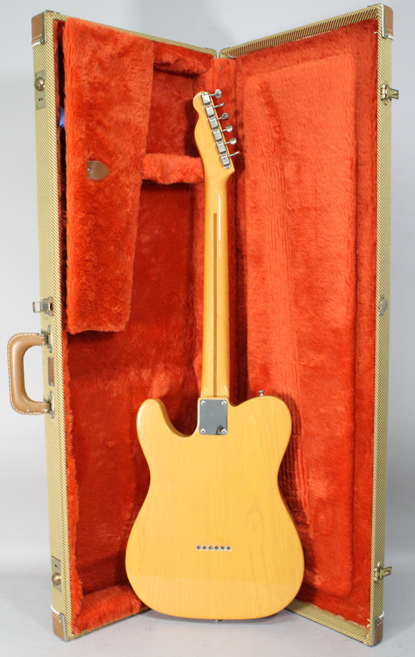 The butterscotch blonde Telecaster is shown from the back, resting in its open tweed hard case with orange plush lining.