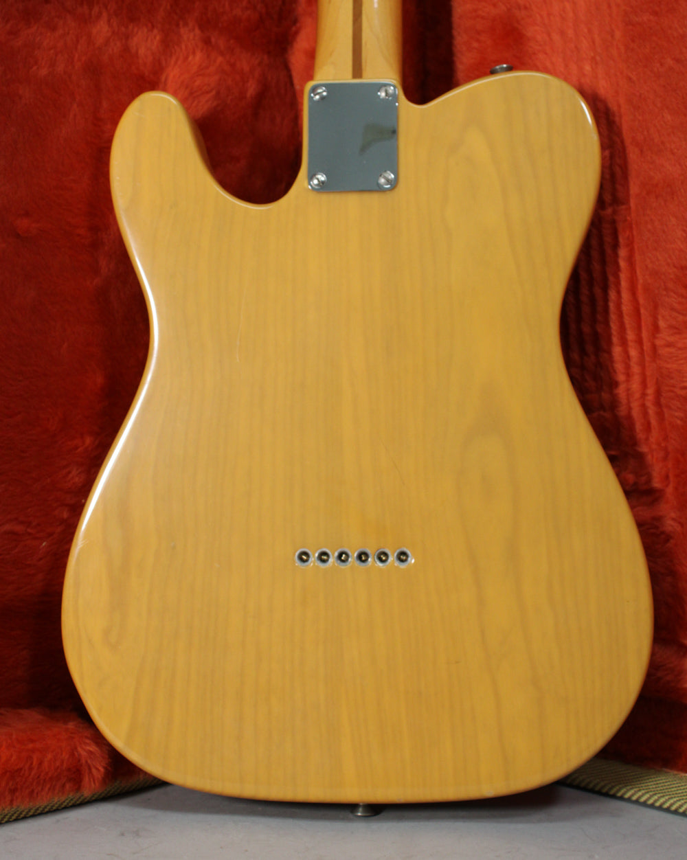 Full back view of a butterscotch blonde Telecaster, showing the neck plate, string-through-body ferrules, and a few minor scuffs.