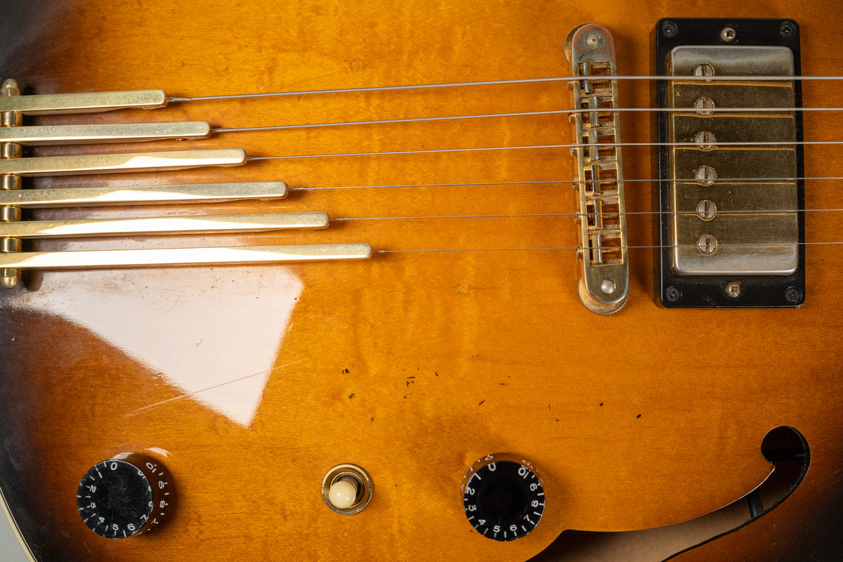 Close-up of the sunburst body, showing the gold trapeze tailpiece, tune-o-matic bridge, bridge humbucker, and two control knobs.