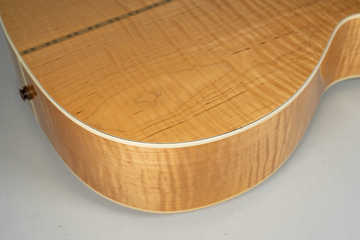 Close-up of the lower bout, showing the natural flame maple top and side with white binding and dark purfling.