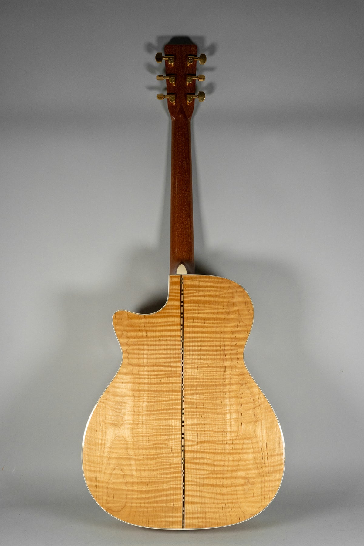 Full rear view of a natural finish flame maple acoustic guitar with a cutaway, dark binding, and gold tuners.