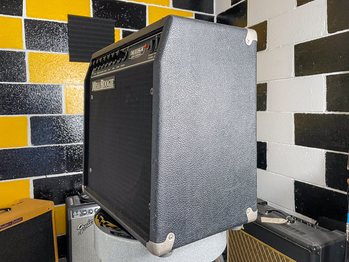 Black textured combo amp, angled from the right, showing the front grille, control panel, and right side with metal corner protectors.