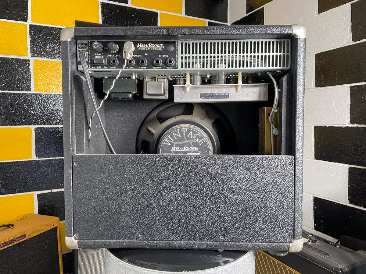 Rear view of a black textured combo amp, showing the control panel, exposed tubes, and a "Vintage Mesa/Boogie" speaker.